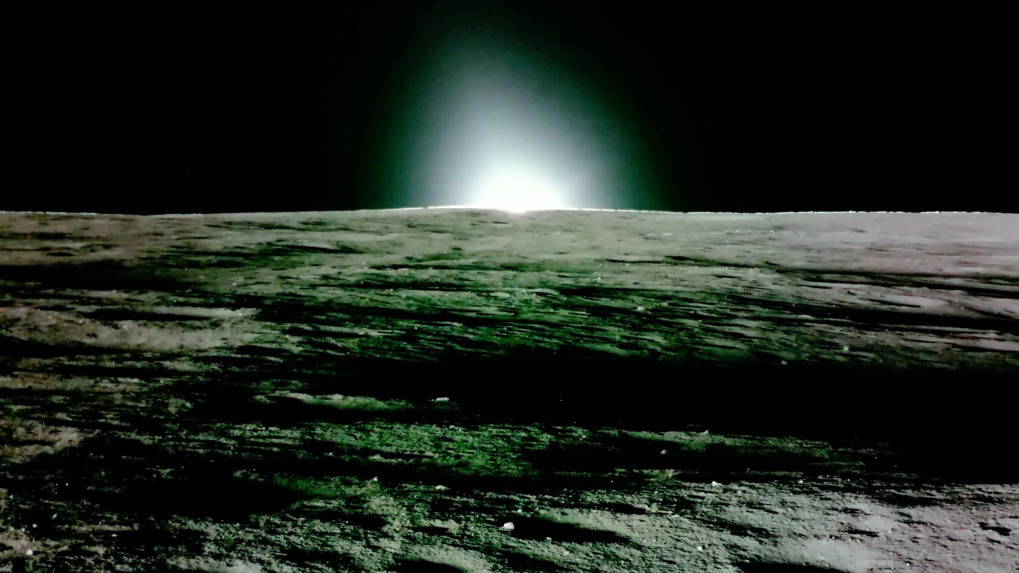 Foto von der Oberfläche des Mondes, die die untergehende Sonne mit einem schwarzen Himmel im Hintergrund zeigt.