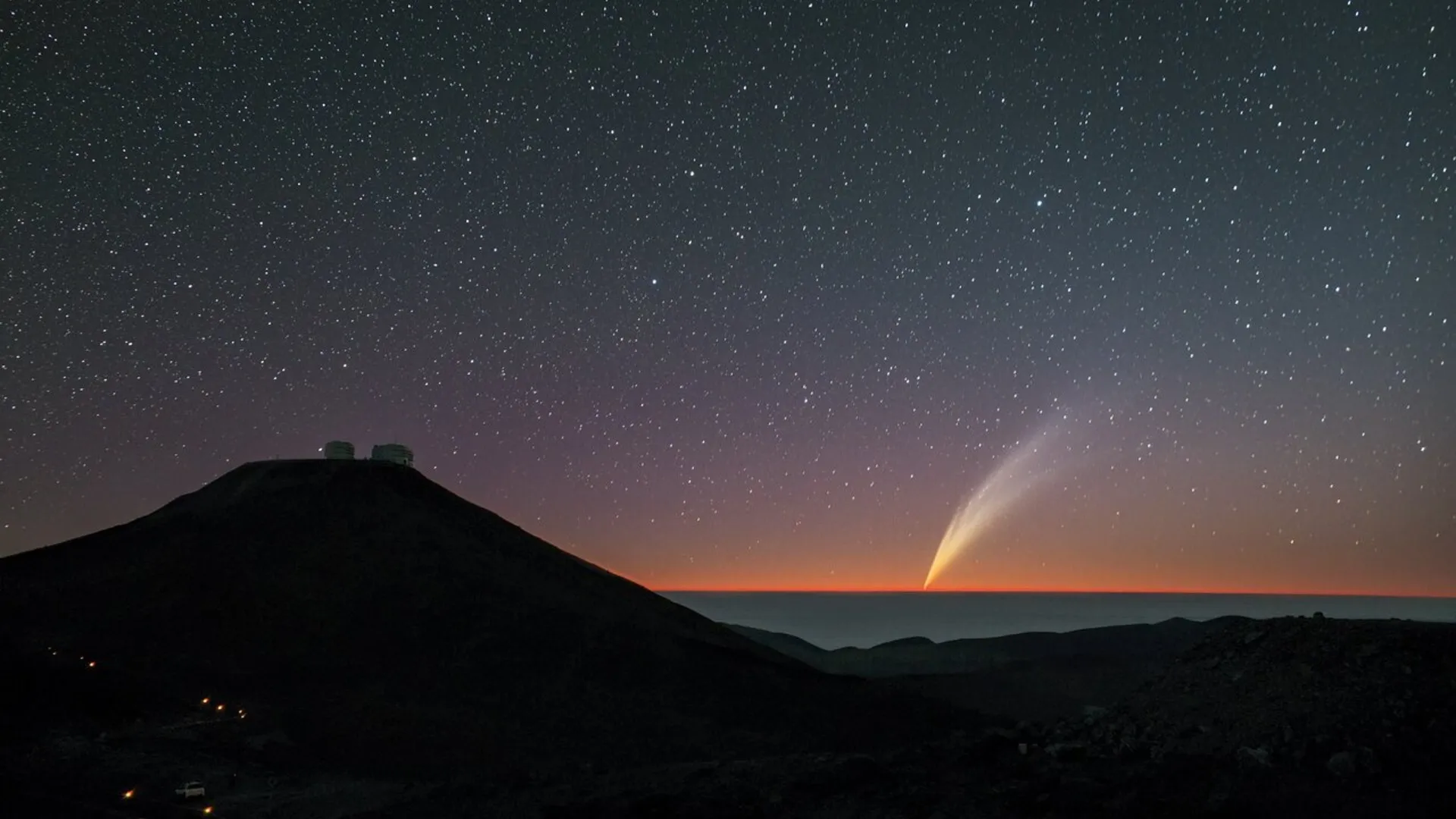 Ein heller Lichtstreifen nähert sich dem Horizont unter einem sternenübersäten Sonnenuntergang.