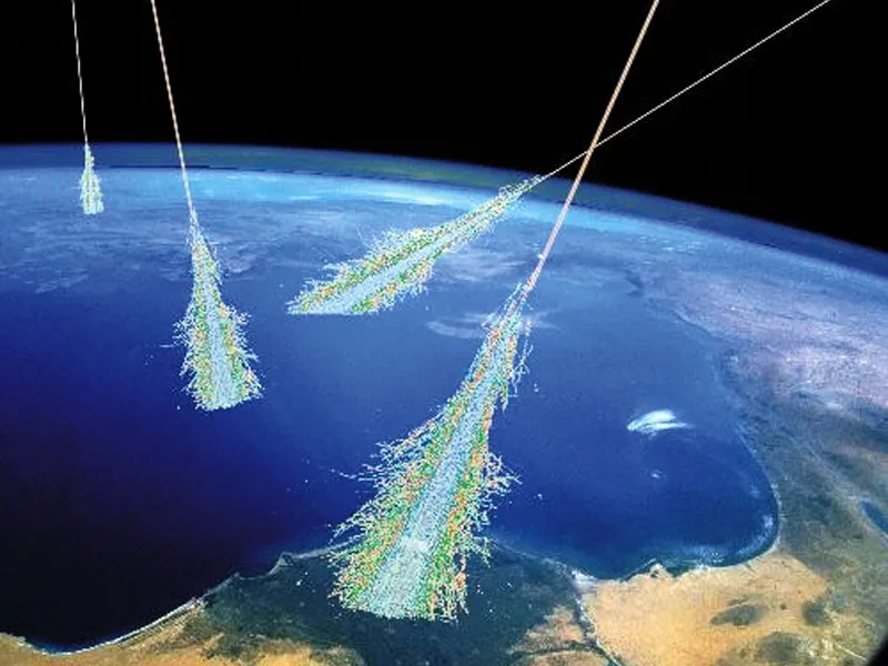 Schauer hochenergetischer Teilchen entstehen, wenn energiereiche kosmische Strahlung auf die obere Erdatmosphäre trifft. Die meisten kosmischen Strahlen sind Atomkerne: die meisten sind Wasserstoffkerne, einige sind Heliumkerne, und der Rest besteht aus schwereren Elementen. Obwohl viele der niederenergetischen kosmischen Strahlen von unserer Sonne stammen, bleibt der Ursprung der höchstenergetischen kosmischen Strahlung unbekannt und ist ein viel erforschtes Thema. Diese Zeichnung veranschaulicht Luftschauer von sehr hochenergetischer kosmischer Strahlung.