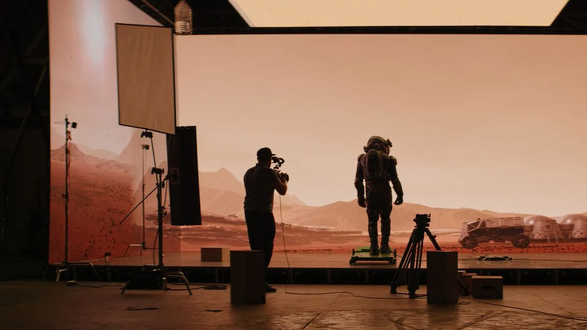 Astronaut am Filmset auf dem Mars, mit einem Kameramann, der die Szene filmt.