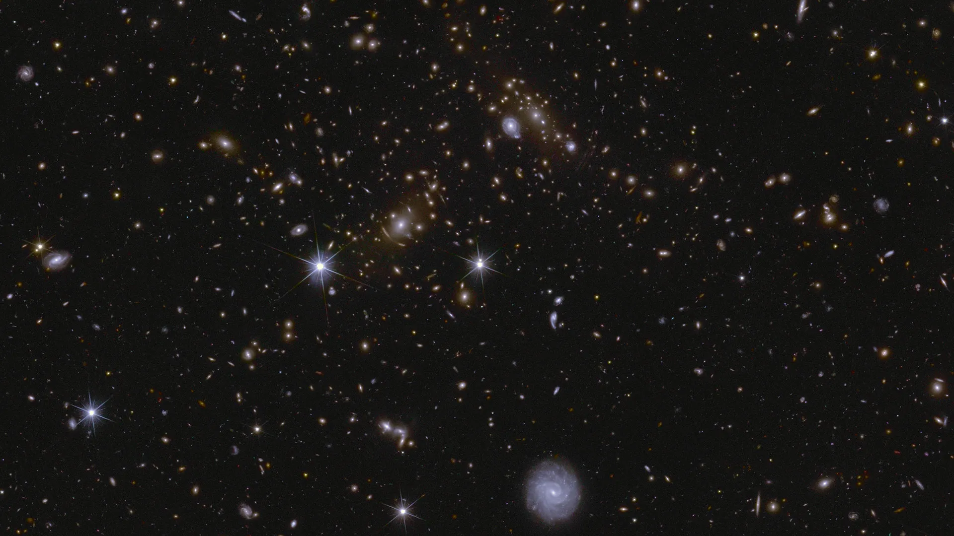 Galaxien in vielen verschiedenen Formen und Größen, in alle Richtungen ausgerichtet, viele mit sichtbaren Spiralarmen.